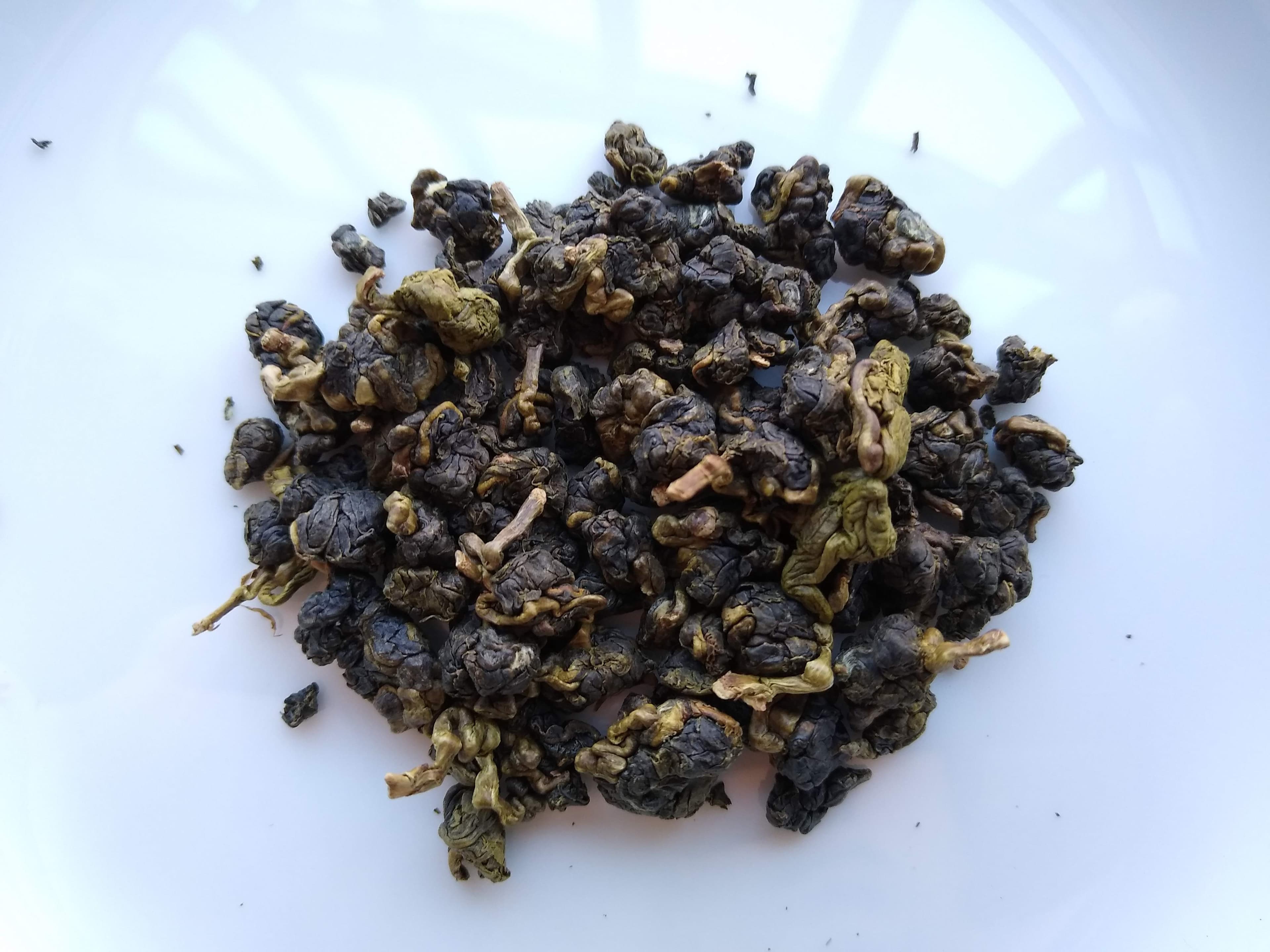 白色容器中呈球狀的台灣高山茶乾茶葉